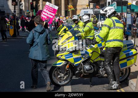 Protest taking place in London on UN Anti Racism Day. Police outriders ready to provide escort Stock Photo