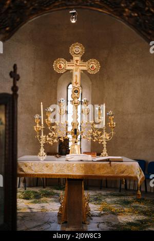 Branched gold candlestick on a table in front of a cross in the Church of St. Sava in Tivat Stock Photo