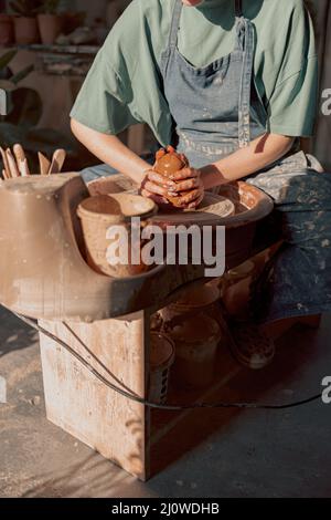 Potter working manually on pottery wheel in workroom Stock Photo