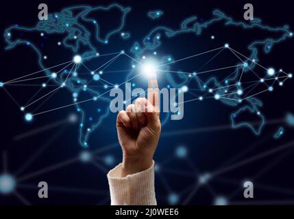 Female hand presses on the connection point and holographic global network with connections. Internet communications, wireless c Stock Photo