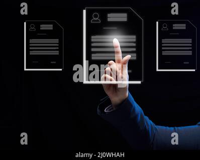 A female hand selects a candidate's resume on a virtual screen. The concept of finding employees, career advancement Stock Photo