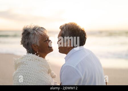 Side view of happy multiracial senior couple looking at each other romantically during sunset Stock Photo