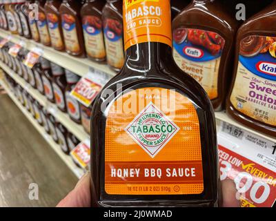 Grovetown, Ga USA - 03 19 22: Retail store shelf hand holding Tabasco BBQ sauce Stock Photo