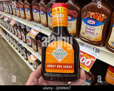 Grovetown, Ga USA - 03 19 22: Retail store shelf hand holding up Tabasco BBQ sauce Stock Photo