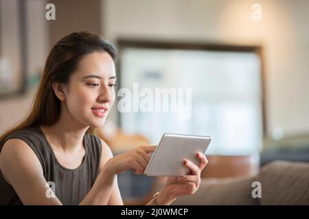Successful Chinese businesswoman working with digital tablet in cafe Stock Photo