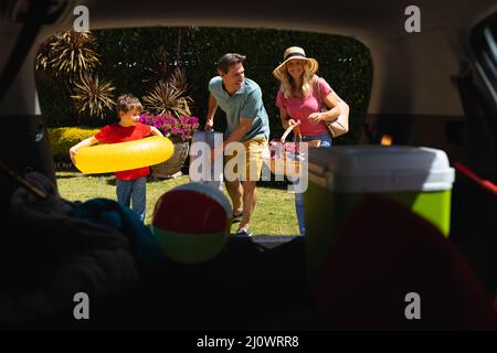 Happy caucasian family putting all their luggage in car Stock Photo