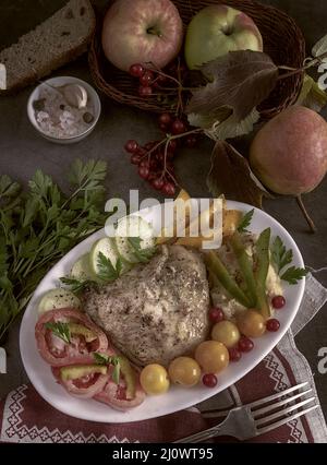 Baked chicken leg on a plate with vegetables Stock Photo