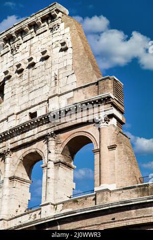 Rome, Italy. Arches archictecture of Colosseum exterior with blue sky background and clouds. Stock Photo