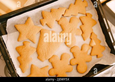 Freshly cooked gingerbread on a baking sheet from the oven, close-up of various shapes of cookies. Stock Photo