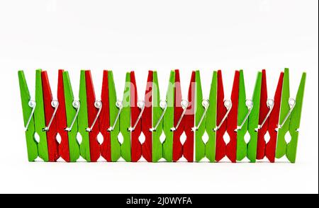 red and green colorful wooden clothespins on a white background Stock Photo