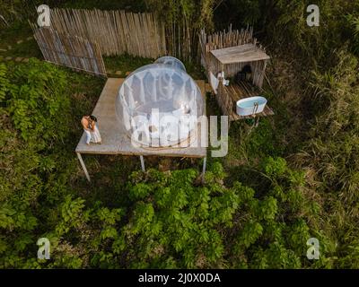 Bubble dome tent glamping in the mountains of Chiang Mai Thailand,Transparent bell tent with comfortable bed and pillow in fores Stock Photo