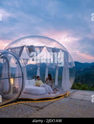 Bubble dome tent glamping in the mountains of Chiang Mai Thailand,Transparent bell tent with comfortable bed and pillow in fores Stock Photo