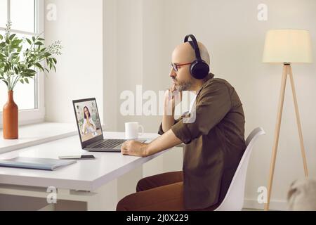 Attentive focused man watching business training, online webinar or talking on video call. Stock Photo