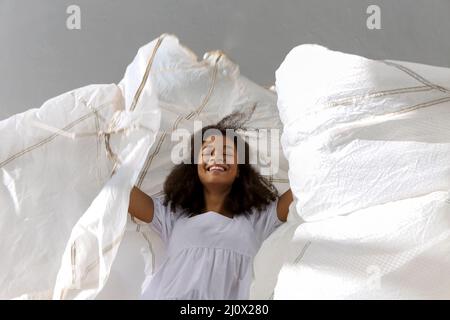 Overjoyed happy african american woman jumping with white fabric in air Stock Photo