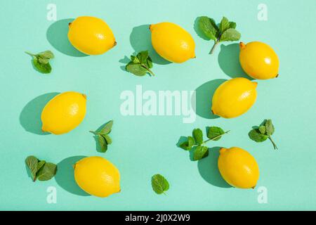 Lemons with mint on minimal blue background sun light hard shadows pattern background Stock Photo