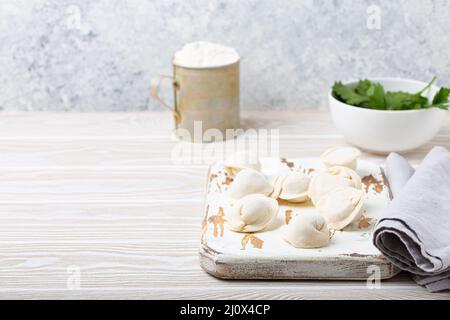 Raw uncooked pelmeni, traditional dish of Russian cuisine, dumplings with minced meat Stock Photo