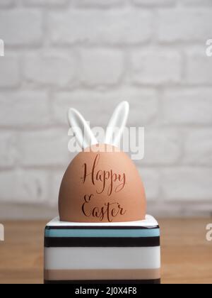Brown organic egg in an egg cup with the inscription Happy Easter Stock Photo
