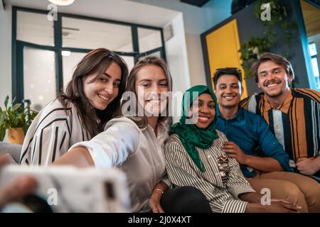Group of business people during break from the work taking selfie picture while enjoying free time in relaxation area at modern Stock Photo