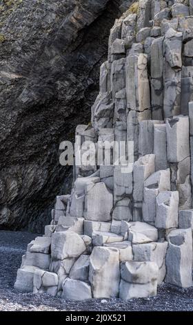 Basalt rock pillars columns at Reynisfjara beach near Vik, South Iceland. Unique geological volcanic formations. Natural stone t Stock Photo