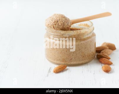 Almond butter, raw food paste made from grinding almonds, glass jar, side view, close up Stock Photo