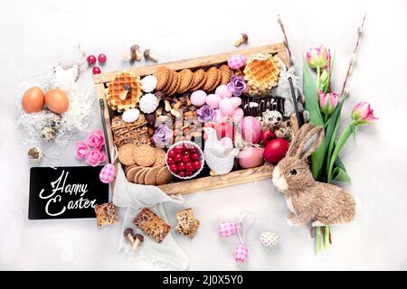 Easter table with an assortment of desserts and treats. Spring holiday food concept. Congratulatory easter background. Top view, flat lay Stock Photo