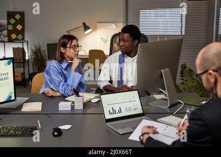 Portrait of diverse business team collaborating while working together in office during meeting, focus on young woman talking to male colleague Stock Photo