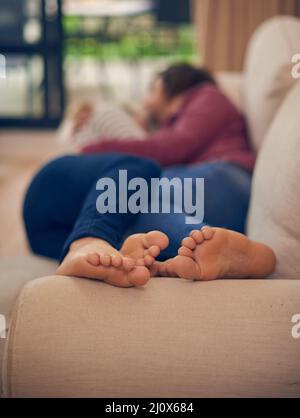 Better together. A young couple napping together on the sofa. Stock Photo