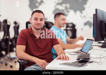 Group of Casual business man working on desktop computer in modern open plan startup office interior. Selective focus Stock Photo