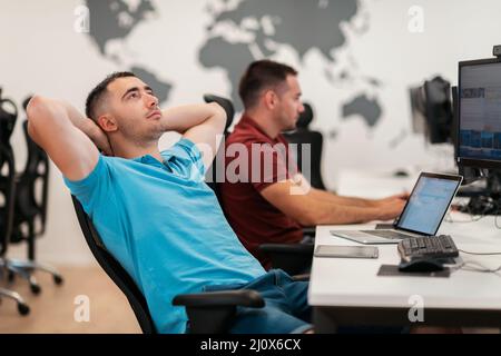 A time for relax. Young tired casual businessman relaxing at the desk in his office. Selective photo Stock Photo