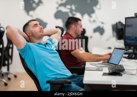 A time for relax. Young tired casual businessman relaxing at the desk in his office. Selective photo Stock Photo