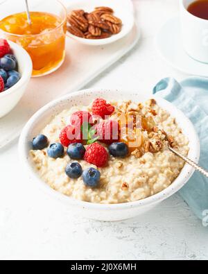 Oatmeal porridge with blueberry, raspberries, side view, close up, vertical, breakfast with berries Stock Photo