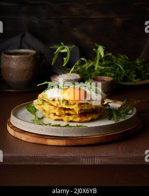 Homemade keto waffles with fried egg, flying arugula, mozzarella cheese. Levitation. Chaffles, keto Stock Photo