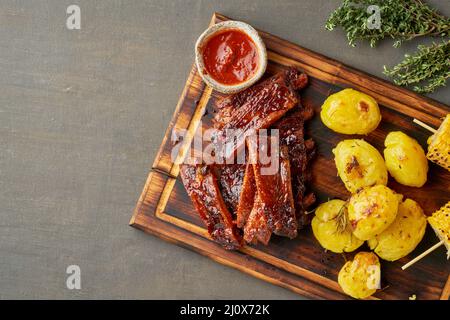 Spicy barbecue pork ribs, corn ears and crushed smashed potatoes. American Cuisine Stock Photo
