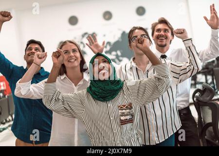 Portrait of young excited multiethnics business team of software developers standing and looking at camera at modern startup off Stock Photo