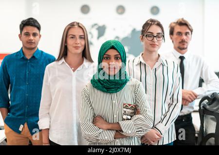 Portrait of young excited multiethnics business team of software developers standing and looking at camera at modern startup off Stock Photo