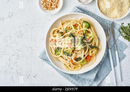 Spaghetti pasta with broccoli, bucatini with peppers, garlic, pine nuts. Top view, copy space Stock Photo
