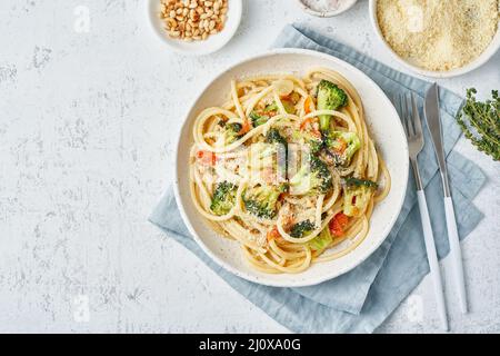 Spaghetti pasta with broccoli, bucatini with peppers, garlic, pine nuts. Top view, copy space Stock Photo