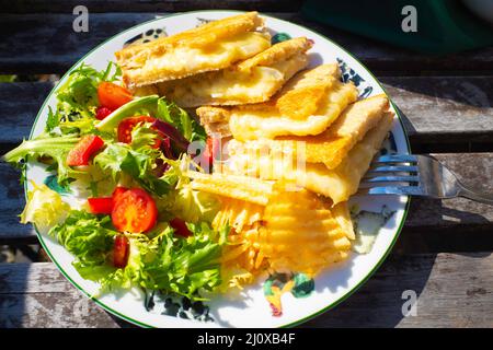 Lunch in a North Yorkshire country café  cheese and onion  toasted sandwich on white bread with salad and potato crisps Stock Photo