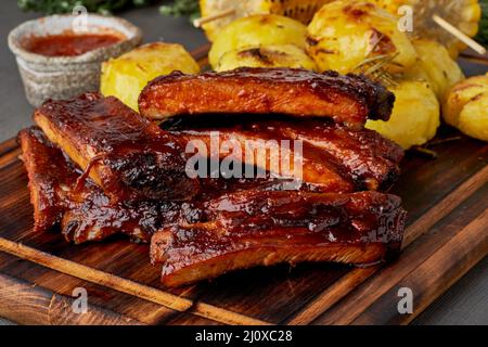 Spicy barbecue pork ribs and crushed smashed potatoes. Slow cooking recipe Stock Photo