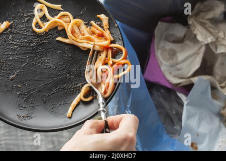 Leftover wasted spaghetti pasta thrown bin. High quality beautiful photo concept Stock Photo