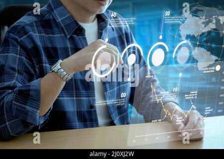 Man in casual cloth interacting with futuristic augmented reality virtual screen of business information and return on investment Stock Photo
