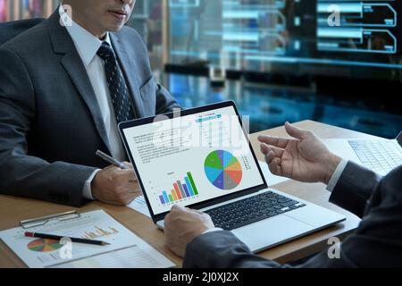 Two businessmen with laptop computer notebook in a modern office analyzing business information on business performance and return on investment Stock Photo