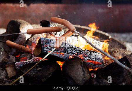 grill sausages over an open fire outdoors Stock Photo