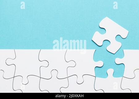 Missing puzzle piece with white puzzle grid blue background. High quality beautiful photo concept Stock Photo