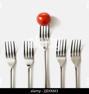 Red cherry tomato fork against white background Stock Photo