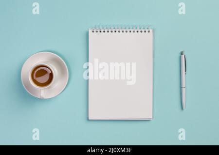 Coffee cup blank spiral notepad pen blue office desk. High quality photo Stock Photo