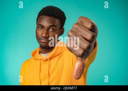 Dissatisfied african american man show thumb down sign in studio Stock Photo
