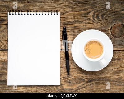 Open notepad with spiral, pen and coffee cup Stock Photo