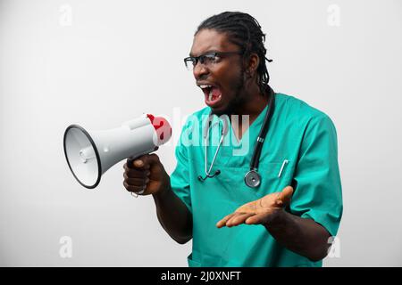 Young black doctor in green uniform using speaker. Stock Photo