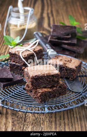Traditional backed American brownies served as close-up on a rustic cake plate on a wooden board Stock Photo